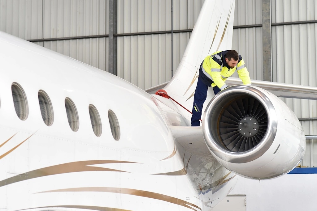 Technician completing a scheduled inspection on a managed private jet